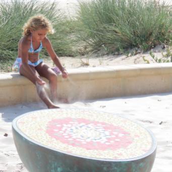 This pretty young girl is playing in the sand